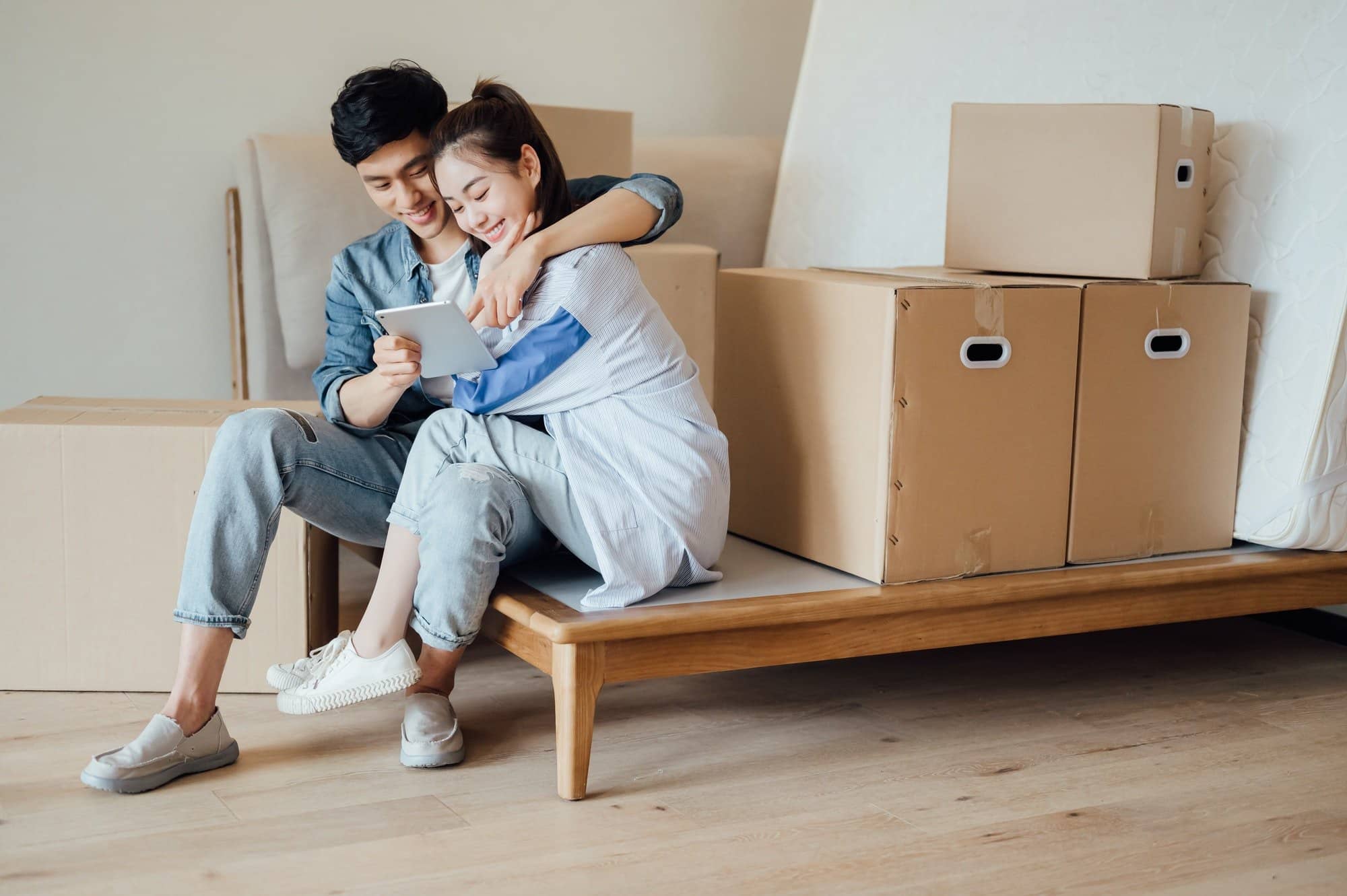 Young couple using ipad during moving house
