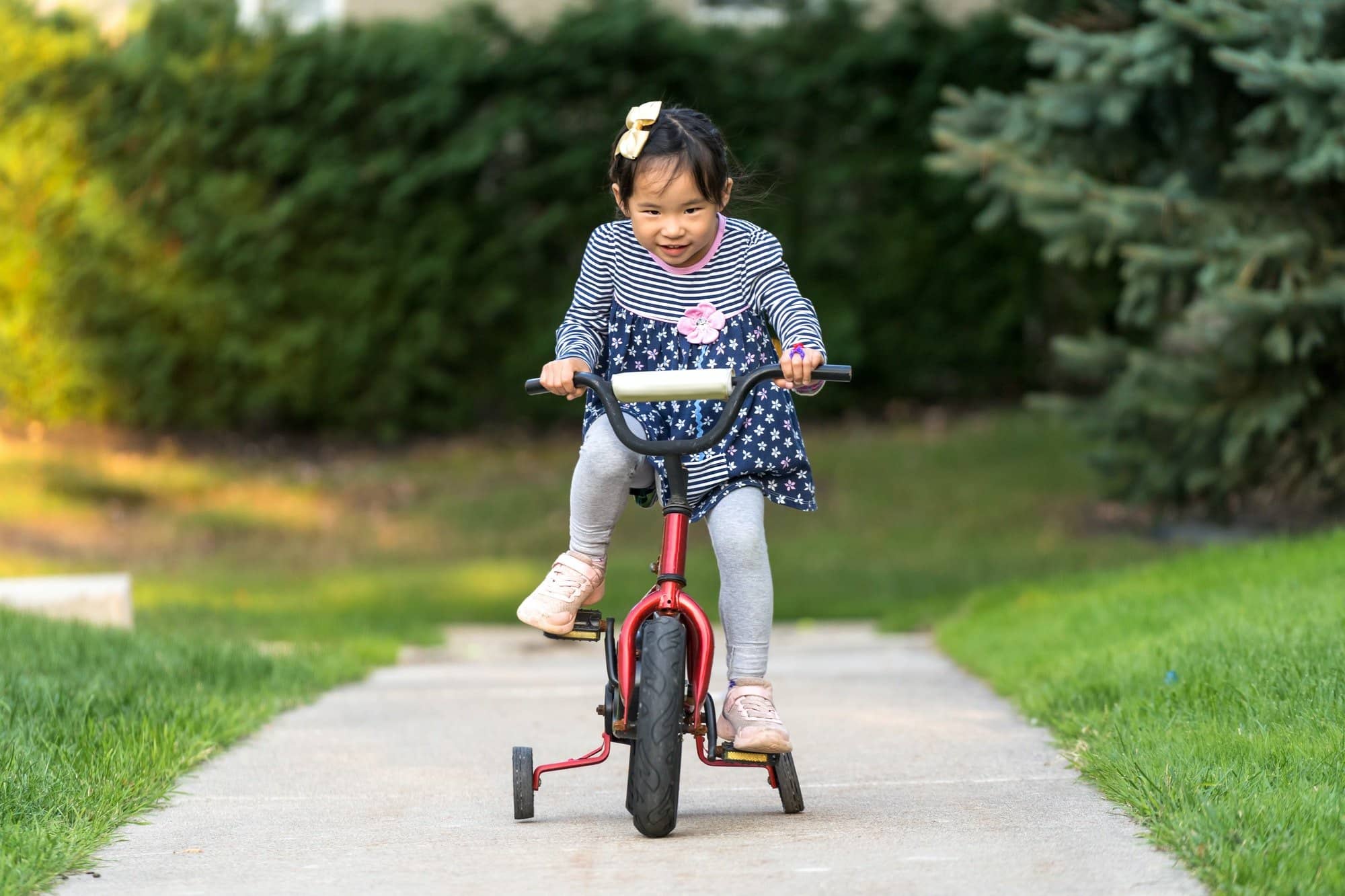 Cute little girl learning ride a bicycle with no helmet